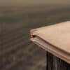 Worker records folder on a fence post representing H-2A back wage documentation